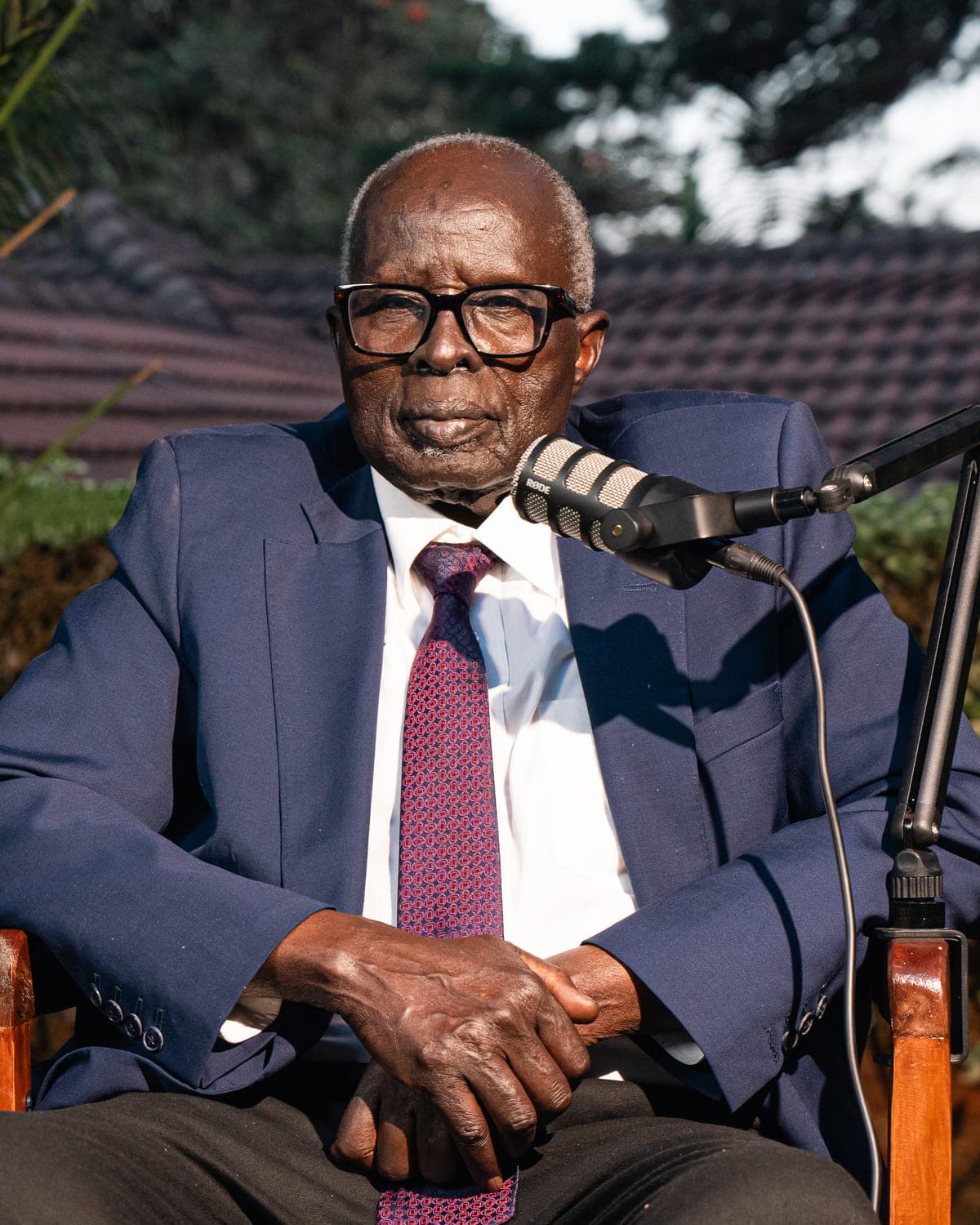 Dr. Aldo Ajou Deng-Akuey, patron of The Nile Explorer, seated at a podcast microphone.